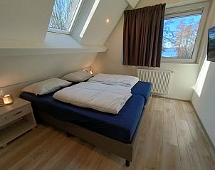 Slaapkamer met uitzicht op de natuur in Vakantiehuis Villa Wellness 8, EuroParcs Veluwemeer, Nunspeet, op de Veluwe.