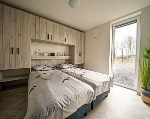 Ruime slaapkamer in Vakantiehuis Villa 10, Nunspeet, Veluwe, met uitzicht op de natuur.