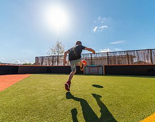 Kind speelt voetbal op grasveld bij Vakantiehuis Villa 10, Nunspeet, Veluwe.