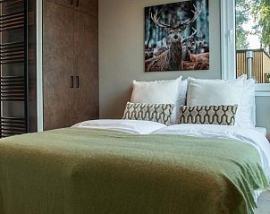 Gezellige slaapkamer in Veluwehoeve 4 personen Wellness, Lunteren, met uitzicht op de natuurlijke omgeving.