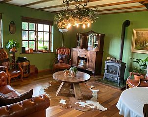 Cozy living room in Holiday Home in Lunteren with rustic decor, warm wood tones and views of the Veluwe countryside.