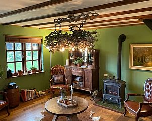 Cozy living room of Holiday Home in Lunteren, Veluwe, Gelderland with rustic furnishings and wood stove for a cozy atmosphere.