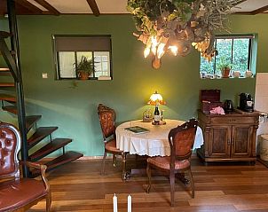 Cozy interior of Holiday Home in Lunteren, Veluwe, Gelderland with cozy furnishings and wooden staircase.