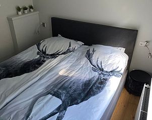 Sfeervolle slaapkamer met hertendecor in vakantiehuisje in Lunteren, Veluwe.