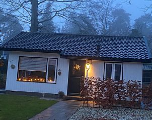 Sfeervol verlicht vakantiehuisje in Lunteren, Veluwe, tijdens de avond.