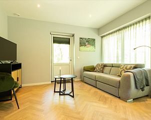 Modern living room in Holiday Home in Lunteren, Veluwe, Gelderland with TV and comfortable sofa.