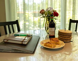 Cozy table at Holiday Home in Lunteren, Veluwe, Gelderland with wine and snacks.
