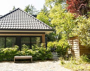 Front view of Holiday home in Lunteren, Veluwe, Gelderland with green garden.