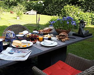 Gezellig ontbijt op het terras van Huisje in Heerde, Veluwe, met uitzicht op de tuin in Gelderland.