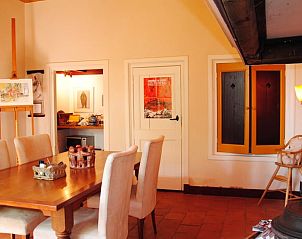 Warme eetkamer in Huisje in Heerde, Veluwe, met houten meubels en kunst in Gelderland.