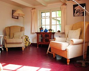 Lichte woonkamer in Huisje in Heerde, Veluwe, met comfortabele stoelen en uitzicht op de natuur in Gelderland.
