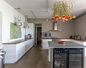 Slaapkamer in DG123 vakantiehuis Teuge Veluwe met kleurrijk dekbed en kunst.