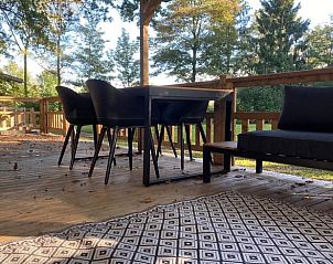 Veranda van vakantiehuisje in Lieren, Veluwe, met comfortabele zitplaatsen en uitzicht op groen.