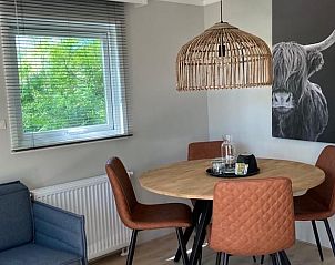 Stijlvolle eetruimte in vakantiehuisje in Lieren, Veluwe, met moderne inrichting en kunst.