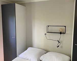 Slaapkamer in vakantiehuisje in Lieren, Veluwe, met comfortabele bedden en minimalistisch design.