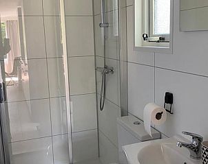 Stijlvolle badkamer in vakantiehuisje in Lieren, Veluwe, met moderne douche en wastafel.