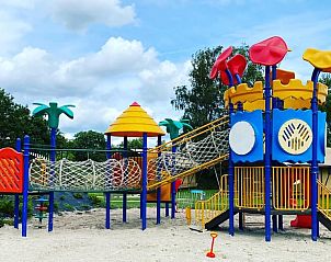 Kleurrijke speeltuin bij vakantiehuisje in Lieren, Veluwe, met glijbanen en klimtoestellen.