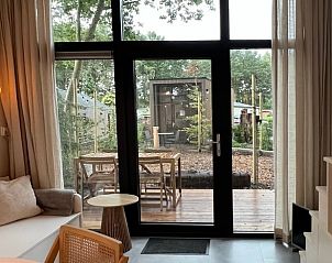 Knusse zithoek in Vakantiehuisje in Lieren met uitzicht op terras.