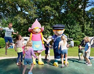 Kinderen spelen met mascottes bij Huisje in Lieren, Veluwe, Gelderland.