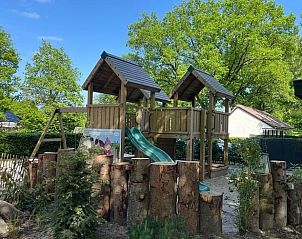 Houten speeltuin bij Vakantiehuis in Lieren, Veluwe, Gelderland, omringd door groen.