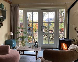 Gezellige woonkamer in Vakantiehuis Laag Soeren, Veluwe met uitzicht op de tuin.