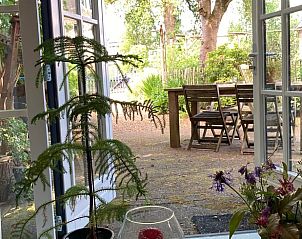 Uitzicht op de tuin vanuit Vakantiehuis in Laag Soeren, Veluwe met open deuren.