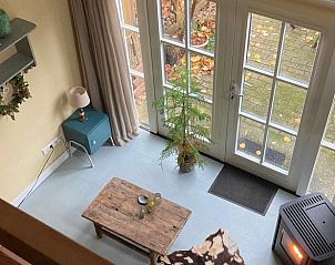 Uitzicht vanuit de bovenverdieping van Vakantiehuis Laag Soeren, Veluwe op de tuin.