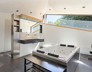 Luxe badkamer met jacuzzi in Huisje in Bennekom, een vakantiehuis op de Veluwe, ideaal voor ontspanning.