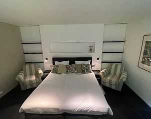 Sfeervolle slaapkamer met comfortabele stoelen in Huisje in Bennekom, gelegen op de Veluwe, Gelderland.