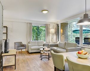 Gezellige eetkamer in Coldenhove bungalow 6B in Eerbeek, Veluwe, met uitzicht op de bosrijke omgeving.