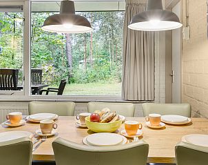 Sfeervolle slaapkamer in Coldenhove bungalow 6B, Eerbeek, Veluwe, met zachte verlichting en kunst aan de muur.