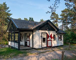 Sfeervolle zithoek in Coldenhove 4-persoons chalet, Eerbeek, Veluwe met wijnglazen en kaarsen.