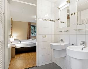 Gezellige woonkamer van Coldenhove 8-persoons bungalow in Eerbeek, Veluwe, met houtkachel en ruime eettafel.