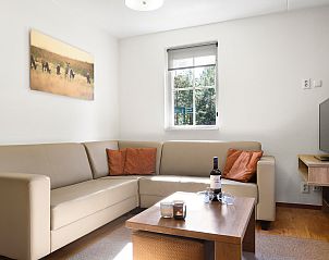Eethoek in Coldenhove bungalow, Eerbeek, Veluwe met houten tafel en leren stoelen.