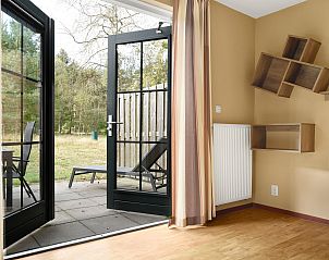 Zonnig terras van Coldenhove vakantiehuis, Eerbeek, Veluwe met parasol en tuinstoelen.