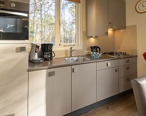 Gezellige woonkamer in Rabbit Hill 4-persoons kinderbungalow in Nieuw Milligen, Veluwe met open haard en uitzicht op de natuur.