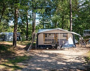 Comfort campingplaats C16 op Rabbit Hill, Nieuw Milligen, Veluwe, Gelderland met stacaravan en bomen.