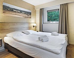 Slaapkamer in Rabbit Hill vakantiehuis, Nieuw Milligen, Veluwe, met comfortabel tweepersoonsbed en rustieke inrichting.