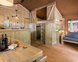 Gezellige woonkamer in Rabbit Hill safaritent, Nieuw Milligen, Veluwe, met houten interieur en zitruimte.