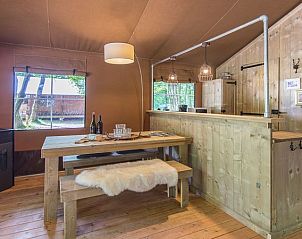 Eetruimte in Rabbit Hill safaritent, Nieuw Milligen, Veluwe, met houten tafel en sfeervolle verlichting.