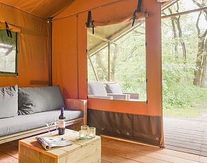 Zitgedeelte in Rabbit Hill safaritent, Nieuw Milligen, Veluwe, met comfortabele bank en toegang tot veranda.
