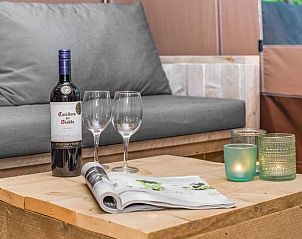 Details van de loungehoek in Rabbit Hill safaritent, Nieuw Milligen, Veluwe, met wijn en glazen.