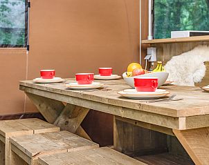 Gedekte tafel in Rabbit Hill safaritent, Nieuw Milligen, Veluwe, met kleurrijk servies en fruit.