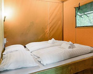 Slaapkamer in Rabbit Hill safaritent, Nieuw Milligen, Veluwe, met tweepersoonsbed en houten interieur.