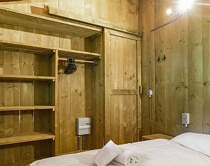 Slaapkamer met opbergruimte in Rabbit Hill safaritent, Nieuw Milligen, Veluwe, met houten kasten.