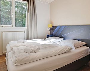 Comfortabele slaapkamer in Rabbit Hill 8-persoons bungalow 8C, Nieuw Milligen, Veluwe, met tweepersoonsbed en natuurlijk licht.