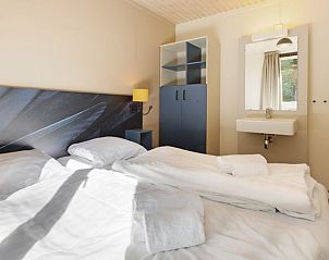 Slaapkamer met wastafel in Rabbit Hill 8-persoons bungalow 8C, Nieuw Milligen, Veluwe, met veel natuurlijk licht.