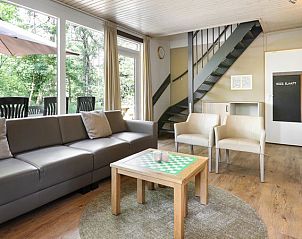 Ruime zithoek in Rabbit Hill kinderbungalow 8CK, Veluwe, met uitzicht op het terras en omringende natuur.