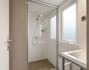 Eethoek met glazen deuren naar terras in Rabbit Hill 6-persoons mobile home, Nieuw Milligen, Veluwe