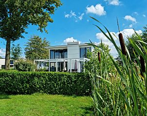 Cube Magnifique 10 vakantiehuis in Nijkerk, Veluwe, Gelderland, omgeven door groene natuur en een zonnig terras.